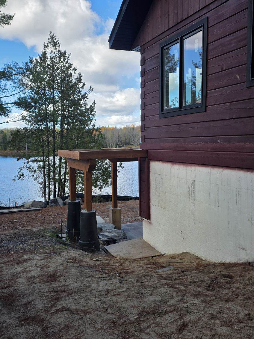 Lakeside view of stained log home exterior